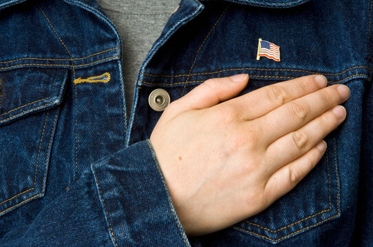 USA flag lapel pin and hand over heart