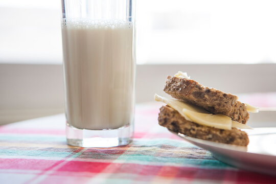 Glass Of Milk And Cheese On Whole Wheat Toast On Colourful Table