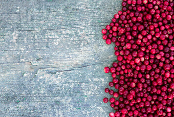 Lingonberry berries on an old wooden board. Place for your text.
