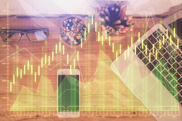 Double exposure of financial graph hologram over desktop with phone. Top view. Mobile trade platform concept.