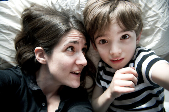 Mother and son take self portrait on bed