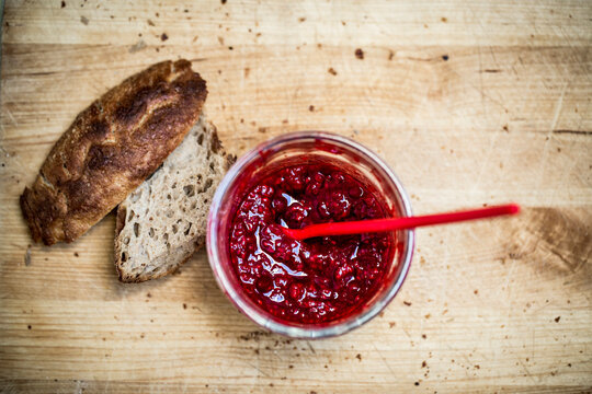 strawberry jam and bread on wooden tray