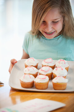 Mother's Day: Girl Happy with Work on Mom's Cupcakes