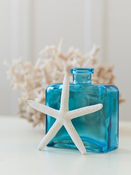 Starfish, glass bottle and coral