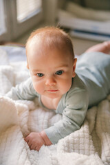 A three-month-old baby lies on his stomach