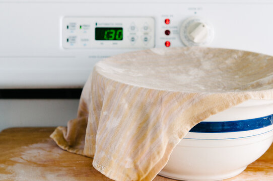 bread dough rising in a bowl on the stove
