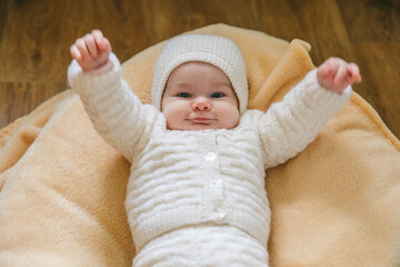 Five month old baby girl in a cute knitted suit. Baby clothes for the winter. Baby shower gifts