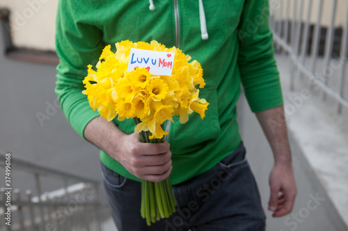 Man holding bouquet of narcissus.