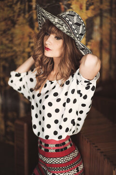 A beautiful woman in a polka dot blouse posing looking away