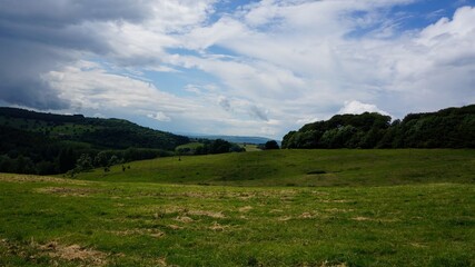 Fototapeta premium landscape, sky, grass, nature, mountain, green, hill, blue, clouds, mountains, field, meadow, summer, countryside, cloud, rural, tree, hills, forest, panorama, beautiful, farm, view, country, valley