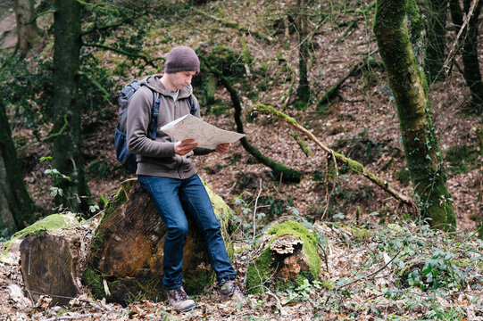 Man sitting in a wood reading a map