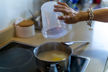 woman cooking soup at home