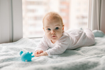 A three-month-old baby reaches for a toy. Psychomotor development and the first toys for a child