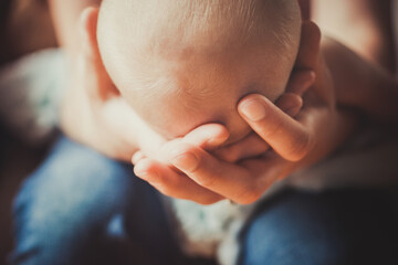 Young mother holds baby in her hands