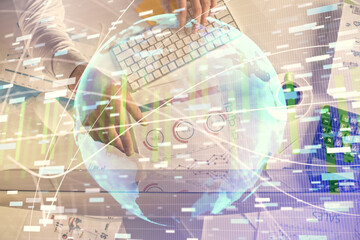 Double exposure of man's hands typing over computer keyboard and business theme hologram drawing. Top view. Financial markets concept.