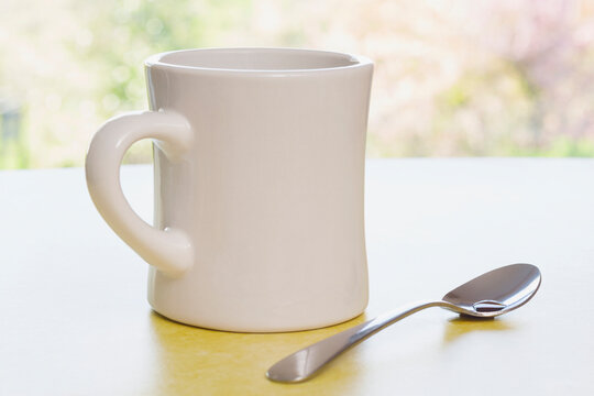 Retro coffee mug with spoon on diner counter near a window