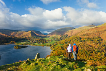 Walkers viewing Grasmere lake and village from Loughrigg Fell, Lake District National Park, Cumbria, UK