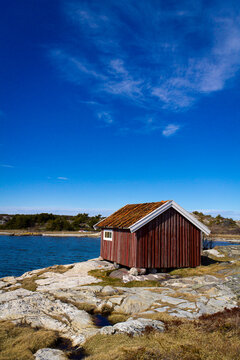 Red boat-house at the sea with a blue sky