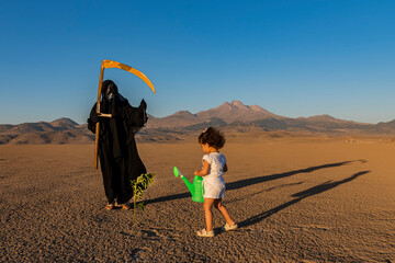 horror grim reaper holding is holding a clock in one hand and a scythe in the other. A green plant...