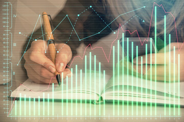 Double exposure of businesswoman hands typing on computer and forex graph hologram drawing. Financial analysis concept.