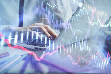 Double exposure of woman hands typing on computer and financial graph hologram drawing. Stock market analysis concept.