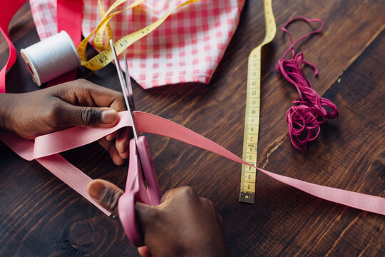 Black girl cutting pink ribbon for a craft
