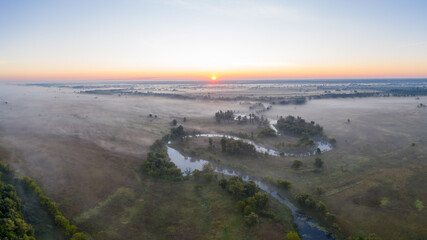 Mystical morning river, the sun's rays shine through the fog.