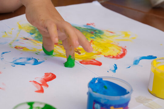 manos de niños pintando con pintura de dedos 