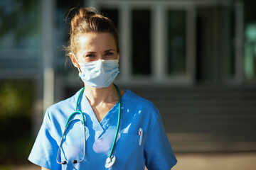 smiling medical practitioner woman outdoors near hospital