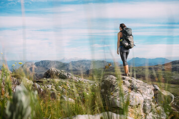 Female hiker with a backpack in the mountains in summer