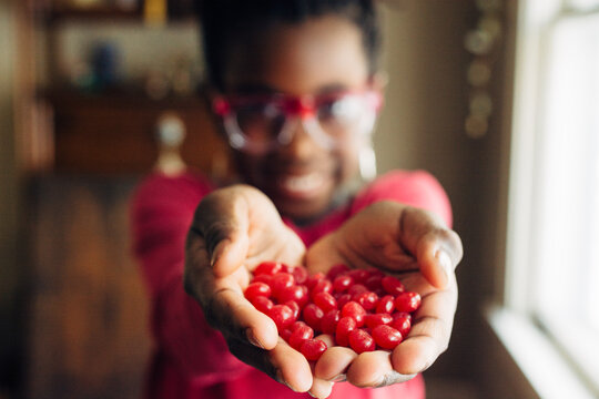 Red candy in the palm of an African American girl