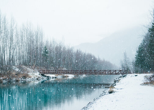 a pedestrian footbridge in falling snow