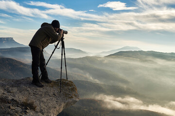 Photographer taking a picture on the edge of a cliff