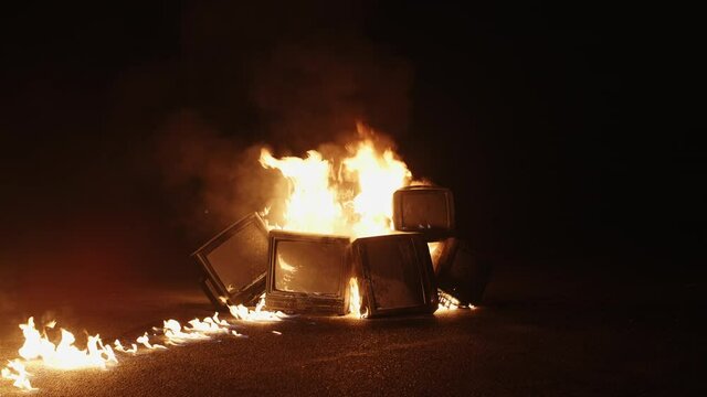 TVs burning in flame of fire. Concept of modern technology, internet and anti-propaganda. Destruction of old TV. Burning television