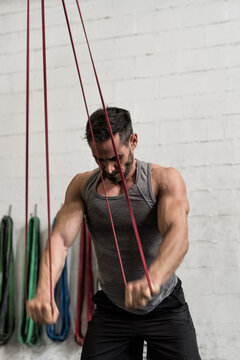 Man Working Out With Resistance Bands In Gym