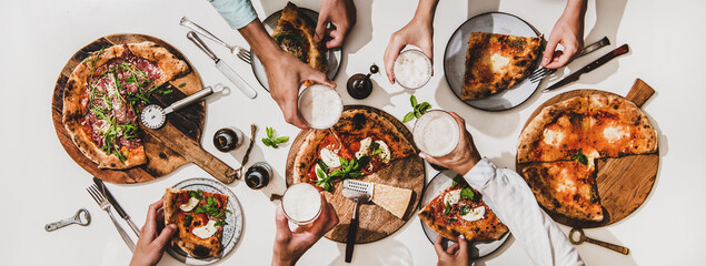 Pizza party for friends or family. Flat-lay of various pizzas, drinks and people celebrating with beer over plain white table background, top view. Fast food, comfort food, Italian cuisine concept - 375007745