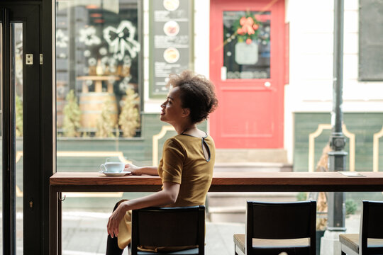Beautiful Young Woman Sitting at the Cafe