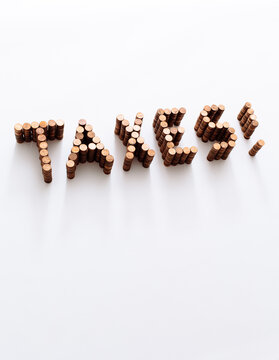taxes spelled in stacks of pennies