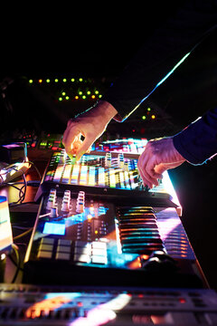 Electronic musician adjusting parameters on a controller
