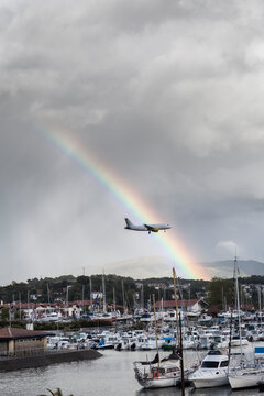 Airplane landing in Irun airport with a rainbow and rainy clouds