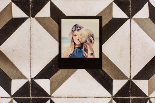 Polaroid of Young Blond Woman Holding Coconut on Vintage Tiles