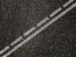 Dotted and solid double white lines on asphalt road.