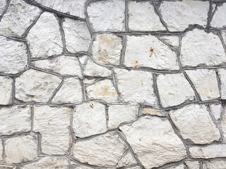 Old bright white pattern stone wall texture.