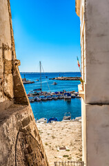 View of the harbor with moored boats from the walls of the Angioino Aragonese castle of Gallipoli, Salento, Italy, originally built in the 13th century by the Byzantines.