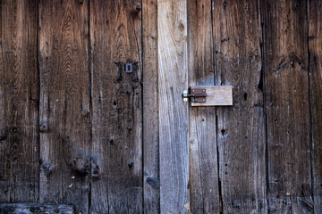 antique wooden door with a latch and a keyhole, background with a worn wooden texture