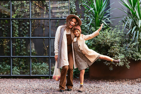 Cheerful woman and girl during family meeting in yard