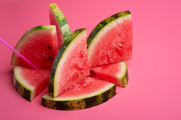 conceptual shot with slices of ripe watermelon at pink background