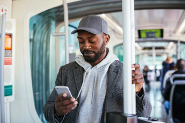 Black guy using smartphone in transport