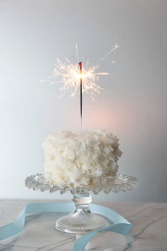 White chocolate cake with sparkler and blue ribbon