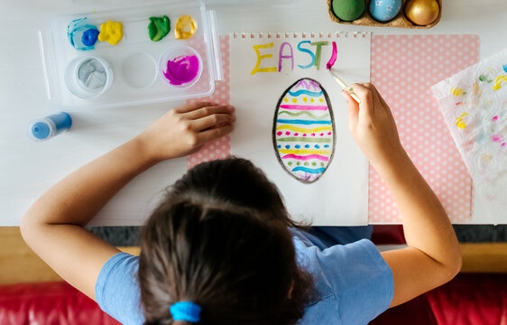Little girl drawing Easter eggs